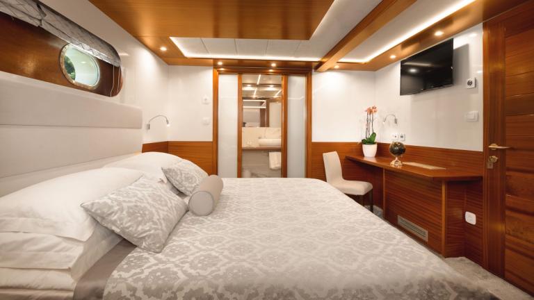 Das gemütliche Doppelbett ist mit verschiedenen Kissen und einer eleganten Tagesdecke ausgestattet.